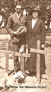 Daneil and Madeline standing beside John's grave, marked by a wooden cross