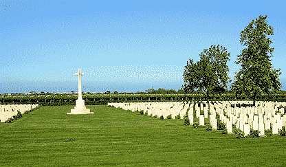 view of the Bari War Cemetery, large cross of sacrifice in the middle, gravestones either site, trees, courtesy Peter Green