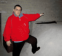 Alan in the cellar, with foot on preservative concrete, by Simon Chambers