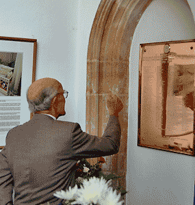 old boy giving the thumbs up sign to the plaque, by Simon Chambers