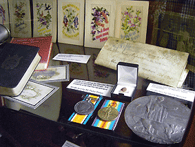some medals, silk postcards, and a dead man's penny