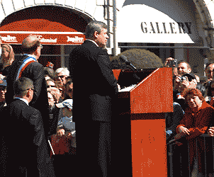 Stephen Harper at a lectern in the square, giving a speech