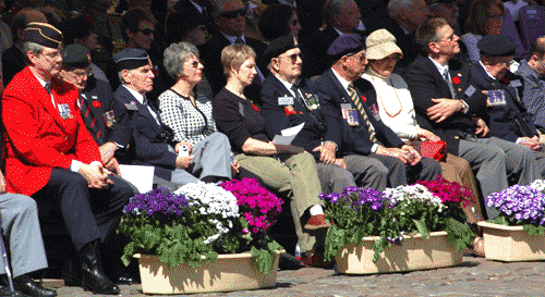 seated by plant pots - the square was decorated with red, white, and blue flowers