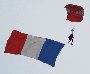 paraglider with a Maple Leaf chute and a large tricoleur flag